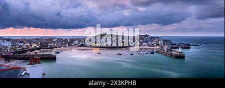 Die Küstenstadt St Ives in Cornwall bei Sonnenuntergang an einem luftigen späten Aprilabend. Mit einer blühenden Künstlergemeinschaft ist St Ives mit Bildern gesäumt Stockfoto