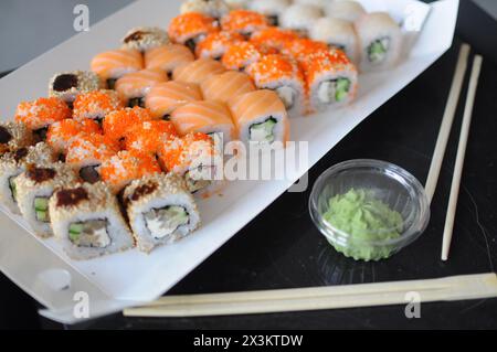 japanisches Sushi. Maki und Brötchen mit Thunfisch, Lachs, Garnelen, Krabben und Avocado. Blick von oben auf verschiedene Sushi. Rainbow Sushi Roll, Uamaki, Hosomaki und Stockfoto