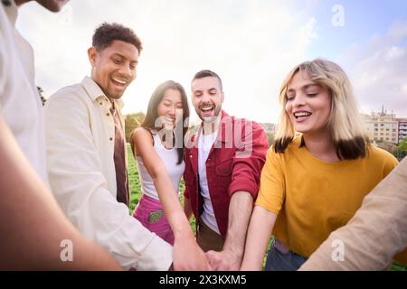 Eine Gruppe junger Geschäftsleute, die sich mit einem gemeinsamen Ziel zusammenschließen und sich solidarisch zusammenschließen. Stockfoto