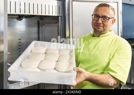 Koch mit Teigbällchen in der Küche, mittlerer Schuss. Hochwertige Fotos Stockfoto