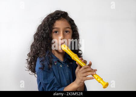 Lateinamerikanisches Mädchen, das mit Geschick die Sopranblockflöte spielt Stockfoto