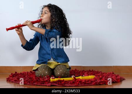 Lateinamerikanisches Mädchen, das mit Geschick die Sopranblockflöte spielt Stockfoto