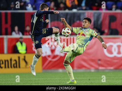 Harrison, NJ, USA. April 2024. Vancouver Whitecaps Mittelfeldspieler Ryan Gauld (25) und New York Red Bulls Mittelfeldspieler Wikelman Carmona (19) springen beide um den Ball während eines MSL-Spiels zwischen den Vancouver Whitecaps FC und den New York Red Bulls in der Red Bull Arena in Harrison, NJ Mike Langish/CSM/Alamy Live News Stockfoto