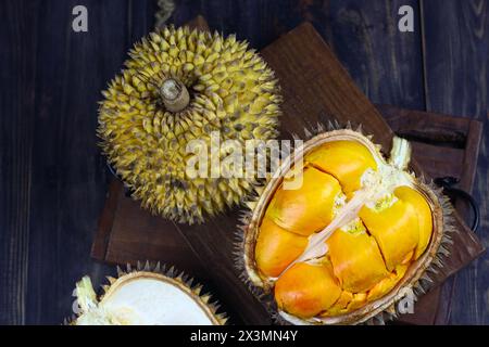 Lai oder Elai Frucht, eine der Borneo endemischen Früchte. Familie mit Durian- oder Durio-Früchten. Dunkles Stimmungsfoto mit hölzernem Hintergrund. Stockfoto