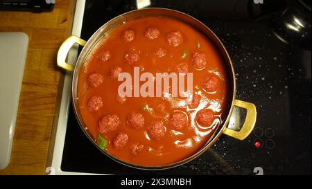 Hausgemachte Fleischbällchen kochen langsam in einer Pfanne mit Tomatensoße Stockfoto