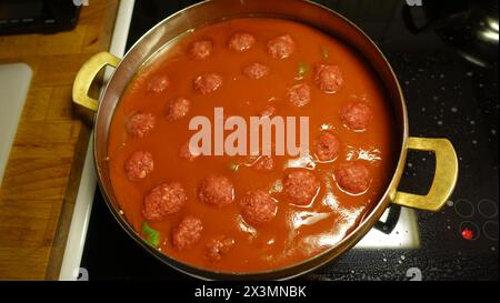 Hausgemachte Fleischbällchen kochen langsam in einer Pfanne mit Tomatensoße Stockfoto