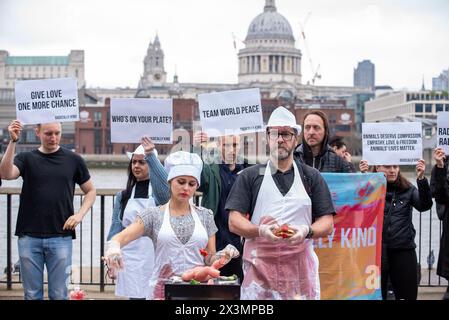 London, Großbritannien. April 2024. (ANMERKUNG DER REDAKTION: Bild enthält Grafikinhalte)Eine Demonstrantin, die als Chefkoch verkleidet ist, grillt eine Babypuppe, die ein Babytier während der Kundgebung symbolisiert. Radikal nett ist vegane Organisation. Sie glauben an Tierrechte und wollen dem Leiden der Tiere Einhalt Gebieten. Sie veranstalteten einen Protest vor der Tate Modern in London, um den Menschen klar zu machen, dass sie sehr oft Babytiere essen. (Foto: Krisztian Elek/SOPA Images/SIPA USA) Credit: SIPA USA/Alamy Live News Stockfoto