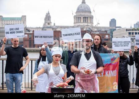 London, Großbritannien. April 2024. (ANMERKUNG DER REDAKTION: Bild enthält Grafikinhalte)Eine Demonstrantin, die als Chefkoch verkleidet ist, grillt eine Babypuppe, die ein Babytier während der Kundgebung symbolisiert. Radikal nett ist vegane Organisation. Sie glauben an Tierrechte und wollen dem Leiden der Tiere Einhalt Gebieten. Sie veranstalteten einen Protest vor der Tate Modern in London, um den Menschen klar zu machen, dass sie sehr oft Babytiere essen. Quelle: SOPA Images Limited/Alamy Live News Stockfoto