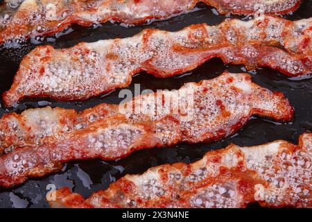 Gebratener Speck in einer Pfanne als Backgrond Stockfoto