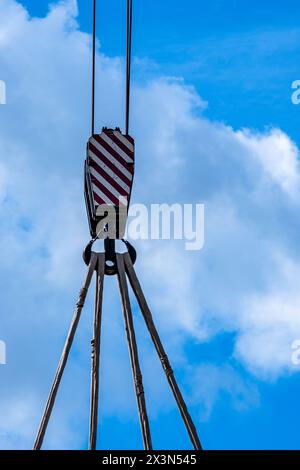 Detailaufnahme eines Kranhakens mit Stahlseilen gegen bewölkten Himmel Stockfoto