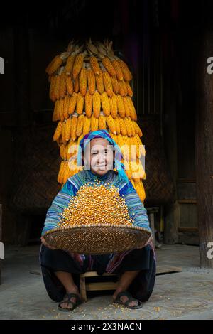 Hmong-Frau, die Mais in Bac Ha in der Provinz Lao Cai, Vietnam winkt Stockfoto