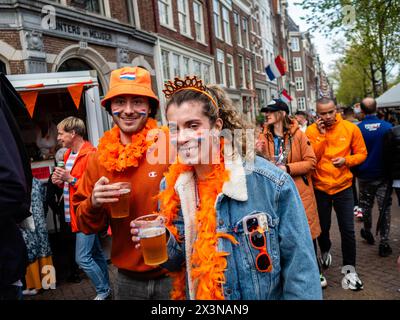 Amsterdam, Niederlande. April 2024. Man sieht Leute trinken auf der Straße. Der Königstag ist bekannt als eines der größten und farbenprächtigsten Festlichkeiten des Landes, besonders in Amsterdam. Die Stadt strotzt vor Orange, während die Menschen die größte Straßenparty des Jahres genießen, die freien Märkte genießen und Spaß auf den Booten entlang der Kanäle haben. Quelle: SOPA Images Limited/Alamy Live News Stockfoto