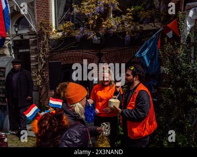 Amsterdam, Niederlande. April 2024. Man sieht Leute, die auf der Straße feiern. Der Königstag ist bekannt als eines der größten und farbenprächtigsten Festlichkeiten des Landes, besonders in Amsterdam. Die Stadt strotzt vor Orange, während die Menschen die größte Straßenparty des Jahres genießen, die freien Märkte genießen und Spaß auf den Booten entlang der Kanäle haben. Quelle: SOPA Images Limited/Alamy Live News Stockfoto