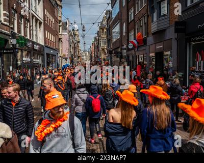 Amsterdam, Niederlande. April 2024. Man sieht Menschen, die orangefarbene Accessoires tragen. Der Königstag ist bekannt als eines der größten und farbenprächtigsten Festlichkeiten des Landes, besonders in Amsterdam. Die Stadt strotzt vor Orange, während die Menschen die größte Straßenparty des Jahres genießen, die freien Märkte genießen und Spaß auf den Booten entlang der Kanäle haben. Quelle: SOPA Images Limited/Alamy Live News Stockfoto