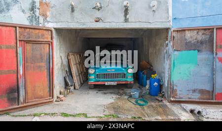 Ein klassisches amerikanisches Auto, das als Taxi benutzt wird, das in einer Garage in der Altstadt von Trinidad, Kuba, gewaschen wird Stockfoto