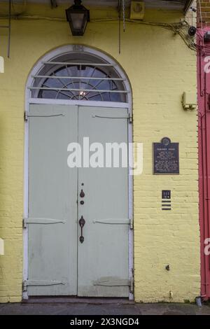 French Quarter, New Orleans, Louisiana.  Piraten Gasse.  William Faulkner-Haus mit gelben Ziegeln um grau-grünen Tür. Stockfoto