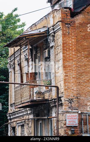 Typisches verfallenes georgianisches Haus in der Altstadt von Tiflis (Georgien). Auf dem Schild steht „Hotel Nicolas“. Stockfoto