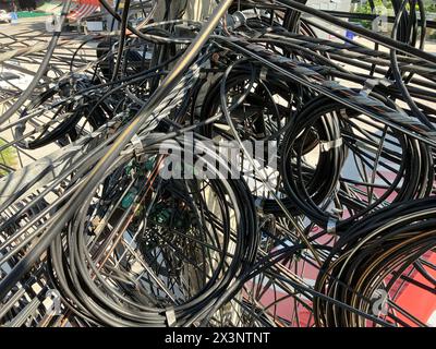 Nahaufnahme von Kabeln und elektrischen Drähten, die am Betonmast hängen. Stockfoto