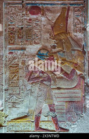 Ein Relief im Tempel von Seti I. in Abydos, Ägypten, zeigt die Göttin Hathor, die den ägyptischen Pharao Ramesses II. Stillt Stockfoto