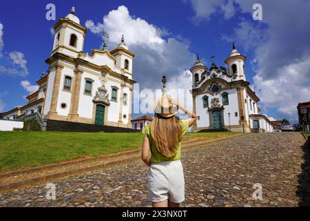 Urlaub in Minas Gerais, Brasilien. Rückansicht des Reisenden Mädchen, das die historische Stadt Mariana mit barocker Kolonialarchitektur besucht. Mariana ist die alte Stockfoto