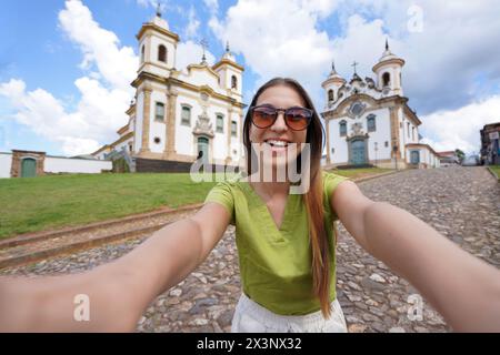 Urlaub in Minas Gerais, Brasilien. Das schöne Traveler Girl macht Selfie mit Smartphone in Mariana, Minas Gerais, Brasilien. Stockfoto