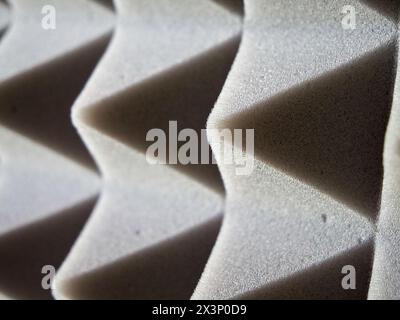 Akustisches Schaumstoffdetail. Graue Schaumstoffpaneele mit Pyramidendesign zur Schalldämmung. Stockfoto