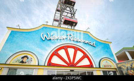 Wien, Österreich. Eintritt zum Riesenrad im Prater-Vergnügungspark mit großen roten Hütten. Großes Attraktionsschild an der Fassade des Buils Stockfoto