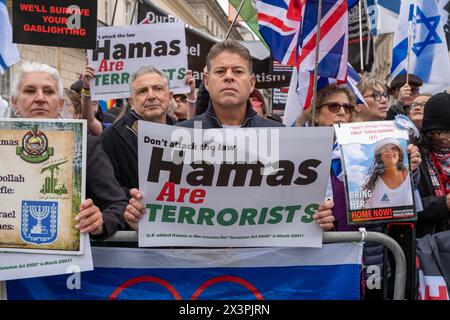 Während der Demonstration wurden Gegenprotestoren gesehen, die Plakate hielten. Nach mehreren Monaten propalästinensischer Märsche in Zentral-London haben die Demonstrationen gegen Hamas und Israel an Größe und Unterstützung gewonnen. Mitglieder der jüdischen und der britischen israelischen Gemeinschaft haben auf dem Weg der großen palästinensischen Märsche, die alle zwei Wochen in Zentral-London stattfinden, Gegenproteste abgehalten. Polizeireihen und Barrieren trennen die beiden Gruppen. Die palästinensischen Gruppen haben erklärt, dass sie weiter marschieren werden, bis es zu einem dauerhaften Waffenstillstand in Gaza kommt.mit wachsender Unterstützung der Gegenprotesten Stockfoto