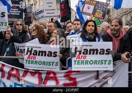 Gegenprotestierende halten während der Demonstration Plakate von Hamas als Terroristen. Nach mehreren Monaten propalästinensischer Märsche in Zentral-London haben die Demonstrationen gegen Hamas und Israel an Größe und Unterstützung gewonnen. Mitglieder der jüdischen und der britischen israelischen Gemeinschaft haben auf dem Weg der großen palästinensischen Märsche, die alle zwei Wochen in Zentral-London stattfinden, Gegenproteste abgehalten. Polizeireihen und Barrieren trennen die beiden Gruppen. Die palästinensischen Gruppen haben erklärt, dass sie weiter marschieren werden, bis es zu einem dauerhaften Waffenstillstand in Gaza kommt.mit wachsender Unterstützung des Gegenpostens Stockfoto