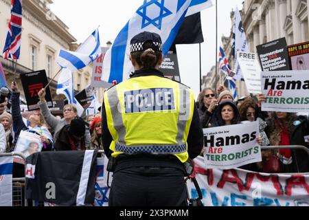 London, Großbritannien. April 2024. Eine Metropolitan Police Officer steht während der Kundgebung vor den Gegenprotestierenden. Nach mehreren Monaten propalästinensischer Märsche in Zentral-London haben die Demonstrationen gegen Hamas und Israel an Größe und Unterstützung gewonnen. Mitglieder der jüdischen und der britischen israelischen Gemeinschaft haben auf dem Weg der großen palästinensischen Märsche, die alle zwei Wochen in Zentral-London stattfinden, Gegenproteste abgehalten. Polizeireihen und Barrieren trennen die beiden Gruppen. Quelle: ZUMA Press, Inc./Alamy Live News Stockfoto