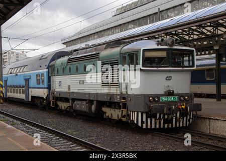 Prag, Tschechien; 25. März: Eine Diesellokomotive der Baureihe 754 der ČD (ehemals ČSD T 478.4) mit einem InterCity-Zug am Prager Hauptbahnhof Stockfoto