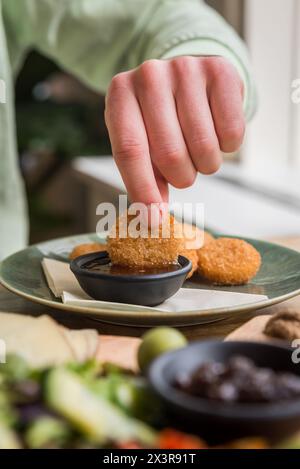 Nahaufnahme von Bratkäse-Snacks, die in süße Chili-Sauce in einem Café-Restaurant getaucht werden Stockfoto