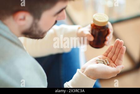 Mann hält eine Flasche Pillen, Draufsicht Stockfoto