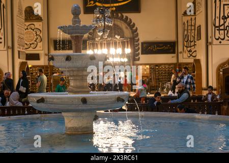 Bursa, Türkei - 13. April 2024: Blick auf das Innere der Großen Moschee und Muslime, die im Brunnen abwässern Stockfoto