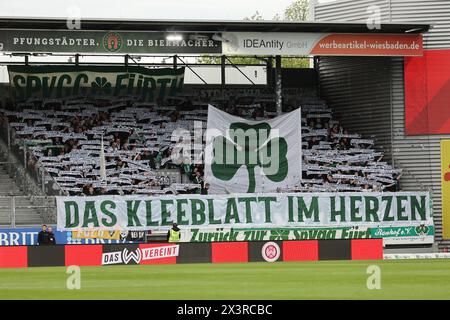 Wiesbaden, Deutschland. April 2024. Fußball: Bundesliga 2, SV Wehen Wiesbaden - SpVgg Greuther Fürth, Spieltag 31, BRITA-Arena. Blick auf die Greuther Fürth Fans im Besucherblock. Quelle: Jörg Halisch/dpa – WICHTIGER HINWEIS: gemäß den Vorschriften der DFL Deutscher Fußball-Liga und des DFB Deutscher Fußball-Bundes ist es verboten, im Stadion und/oder des Spiels aufgenommene Fotografien in Form von sequenziellen Bildern und/oder videoähnlichen Fotoserien zu verwenden oder zu nutzen./dpa/Alamy Live News Stockfoto