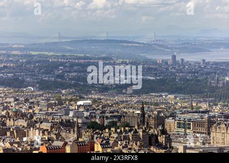 Vom Arthur’s Seat aus hat man einen Blick über Edinburgh, die Princes Street verläuft im Vordergrund und die Forth Bridges in der Ferne Stockfoto