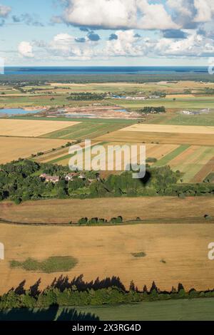 Ländliche Landschaft aus einem Heißluftballon. Litauische landwirtschaftliche Felder am frühen Morgen. Vertikales Foto. Stockfoto