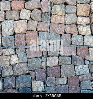 Steinmauer, Gabionenüberzug - Schutz vor Erosion im Backshore-Bereich. Quadratisches Foto. Stockfoto