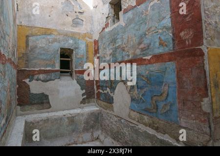 Blick aus dem Inneren der Ruinen der antiken römischen Vorstadtbäder mit wunderschönen farbigen Kunstwerken an der Wand in der zerstörten Stadt Pompeji, Kampanien, Italien Stockfoto