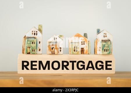 REHYPOTHEKEN, ein Wort auf einem Holzblock mit Miniaturhäusern. Immobiliengeschäft und Finanzkonzept, Kopierraum Stockfoto