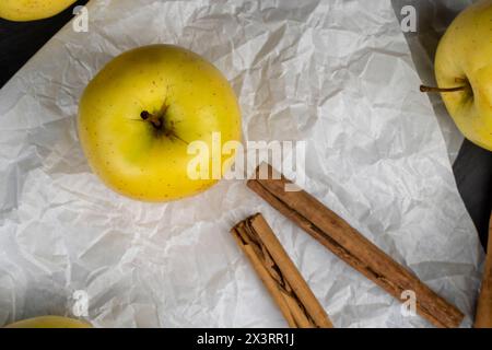 Gelber reifer Apfel mit Zimt auf dem Tisch, Kochzutaten Stockfoto