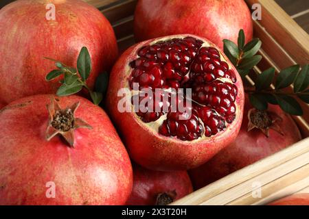 Frische reife Granatäpfel in Holzkiste, Großaufnahme Stockfoto