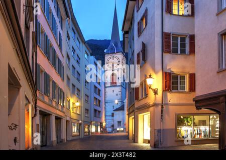 Nachtszene entlang der Oberen Straße im historischen Zentrum von Chur, Bündner, Schweiz mit dem imposanten Turm von St. Martin-Kirche Stockfoto