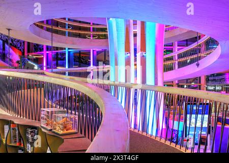 Ein wunderschöner hölzerner Wendeltreppenhaus im Hauptatrium von Exploreit Y-Parc Technopole in Yverdon-les-Bains, Schweiz, bei Nacht hell beleuchtet. Stockfoto