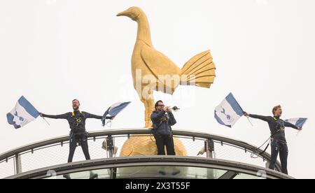 London, Großbritannien. April 2024 - Tottenham Hotspur gegen Arsenal - Premier League - Tottenham Hotspur Stadium. Der Spurs-Trompeter spielt zu Beginn des Spiels „oh, wenn die Spurs gehen marching in“ vor dem Hahnenmaskottchen des Clubs, das sich ganz oben auf dem Dach des Tottenham Hotspur Stadions befindet. Bildnachweis: Mark Pain/Alamy Live News Stockfoto