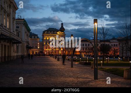 Krakau, Polen, 23. März 2024 - Menschen, die nachts auf dem Platz Nowaka-Jezioranskiego spazieren gehen Stockfoto