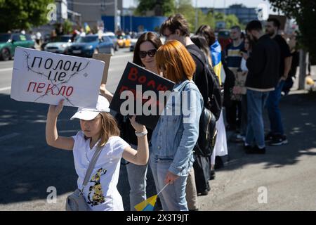 Kiew, Ukraine. April 2024. Ein junges Mädchen hält ein Plakat mit der Aufschrift „Gefangenschaft ist die Hölle“ und „Freiheit für Helden“ während einer Kundgebung, auf der die Behörden aufgefordert werden, ihre Verwandten aus der russischen Gefangenschaft zurückzubringen. Verwandte von Verteidigern der Metallurgieanlage Azovstal veranstalteten eine Kundgebung, in der die ukrainischen Behörden aufgefordert wurden, ihre Angehörigen aus der russischen Gefangenschaft zu befreien und zurückzubringen. (Credit Image: © Oleksii Chumachenko/SOPA Images via ZUMA Press Wire) NUR REDAKTIONELLE VERWENDUNG! Nicht für kommerzielle ZWECKE! Quelle: ZUMA Press, Inc./Alamy Live News Stockfoto