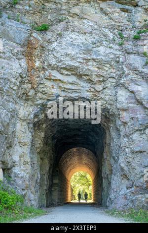 Silhouette eines Paares, der durch einen Tunnel auf dem Katy Trail in der Nähe von Rocheport, Missouri, läuft. Der Katy Trail ist ein 237 km langer Radweg, der aus einer alten Ra umgebaut wurde Stockfoto