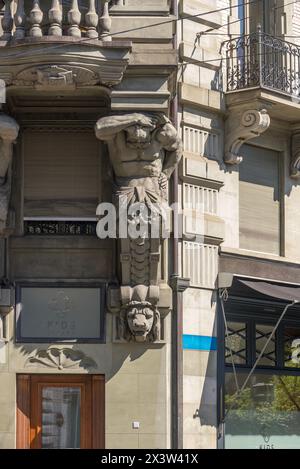 Eine Statue in der Fassade eines historischen Gebäudes mit einem klassischen Mann und einem Löwenkopf. Luzern, Schweiz. Stockfoto