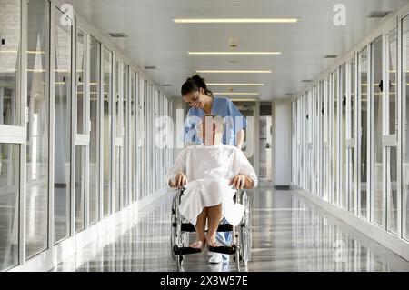 Krankenschwester drängen Patienten im Rollstuhl Stockfoto